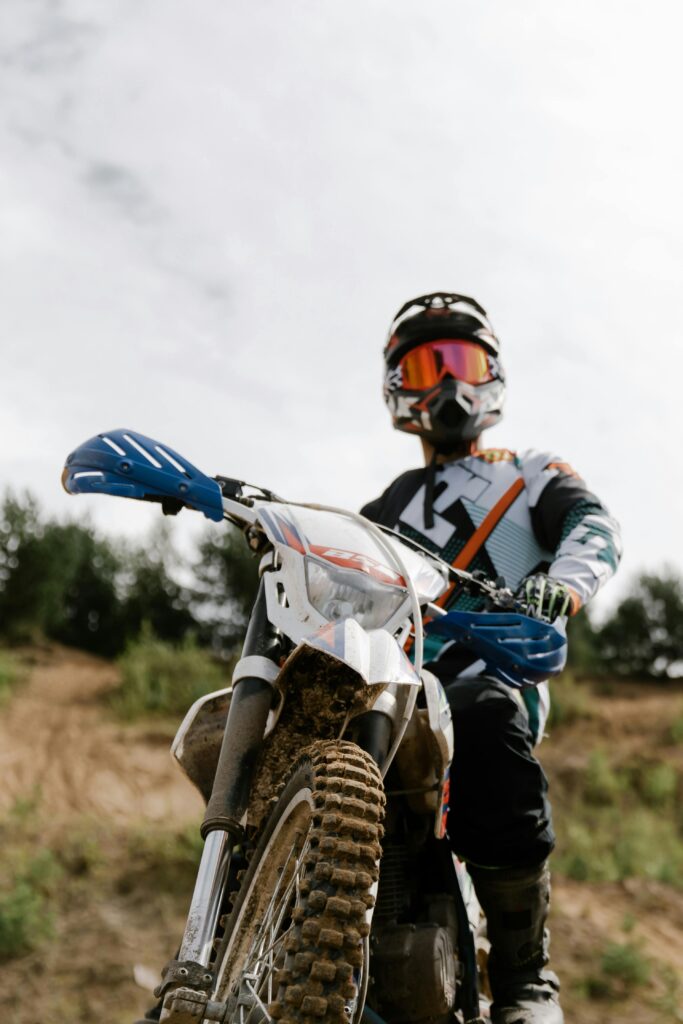 Dirt bike rider wearing protective gear, showcasing extreme sports on a challenging off-road trail.